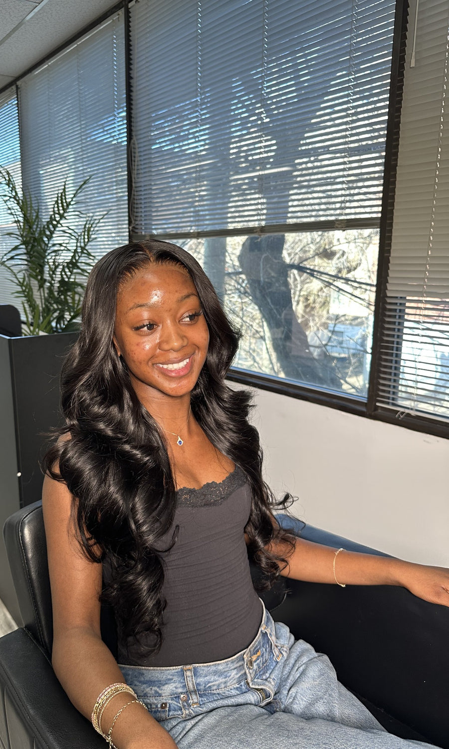 Client wearing installed Body Wave bundles — portrait crop